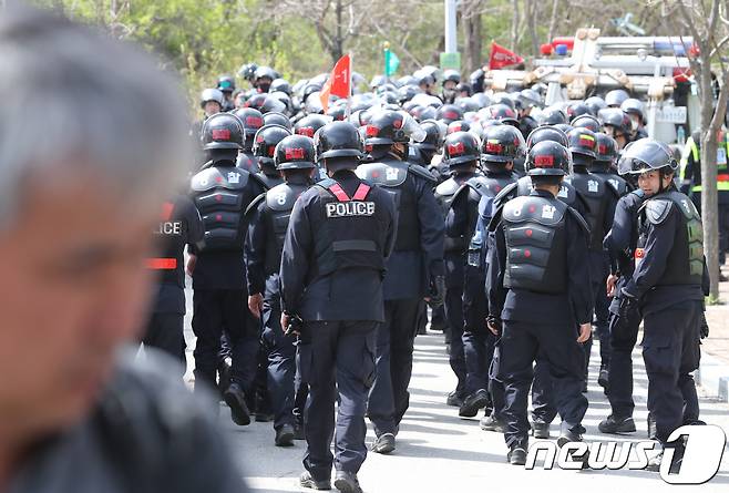 12일 국방부가 주한미군 성주 사드(THAAD·고고도미사일 방어체계) 기지 내 환경개선 공사를 위해 장비를 투입하려던 시도가 주민과의 합의로 일단락됐다. 경북 성주군 초전면 소성리 진밭교에서 사드 반대 단체와 주민 해산작전에 투입된 경찰 병력이 철수하고 있다. 2018.4.12/뉴스1 © News1 공정식 기자