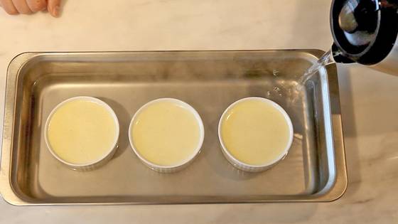 오븐팬에 뜨거운 물을 채우고 크릇에 담은 크림 혼합물을 오븐에 중탕으로 굽는다.