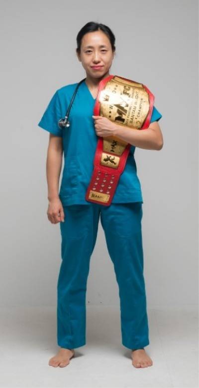 간호사 복장으로  챔피언 벨트를 어깨에 두른 채 포즈를 취하고 있는 김효선.