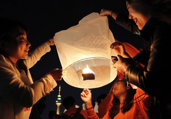 지난해 4월 22일 오후 대구시 달서구 두류야구장에서 불기 2561년 부처님 오신날을 봉축하는 연등축제가 열렸다. 법요식을 마친 뒤 달구벌 관등놀이의 백미로 불리는 소원 풍등 날리기가 시작되자 시민들이 소원을 적은 형형색색 풍등을 하늘로 날려 보내고 있다. [중앙포토]