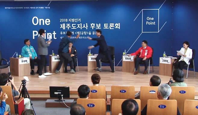 (제주=연합뉴스) 박지호 기자 = 14일 오후 제주시 벤처마루에서 열린 ‘2018 지방선거 제주도지사 후보 원포인트 토론회’에서 제주 제2공항 반대 활동을 했던 김경배씨가 무대에 올라가 원희룡 예비후보를 폭행하고 있다. 2018.5.14 [원희룡 캠프 제공=연합뉴스]