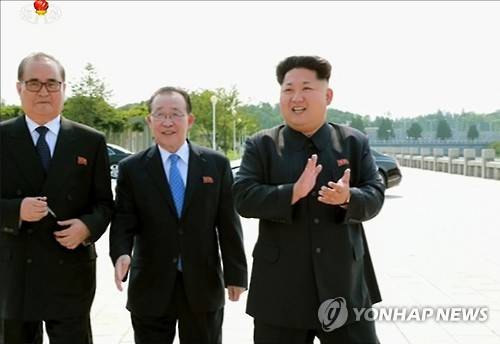 외교관들 만나 박수 치는 김정은 (서울=연합뉴스) 김정은 국방위원회 제1위원장이 '대사회의'에 참석한 북한 외교관들과 함께 기념사진을 찍었다고 15일 조선중앙통신이 보도했다. 최근 해외 주재 북한 중간 간부들의 동요가 커지고 있는 가운데 김정은 제1위원장이 이례적으로 이들을 만나 사진을 찍으며 '군기 잡기'에 나선 것이라는 분석이 나온다. 사진은 박수를 치는 김정은 제1위원장과 리수용 외무상(왼쪽), 김계관 외무성 제1부상(가운데)의 모습을 조선중앙TV 화면에서 캡처한 것. 2015.7.15