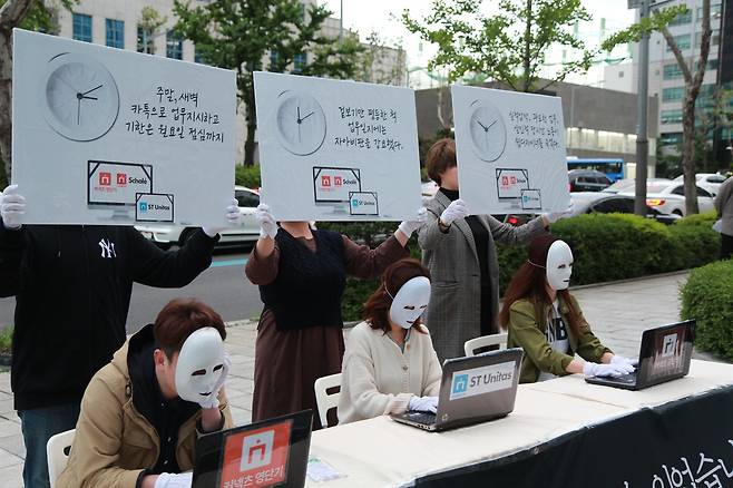 공인단기스콜레디자이너과로자살대책위원회가 에스티유니타스 본사 앞에서 <장시간노동을멈춰라>플래시몹을 진행하고 있다. ⓒ공인단기스콜레디자이너과로자살대책위원회