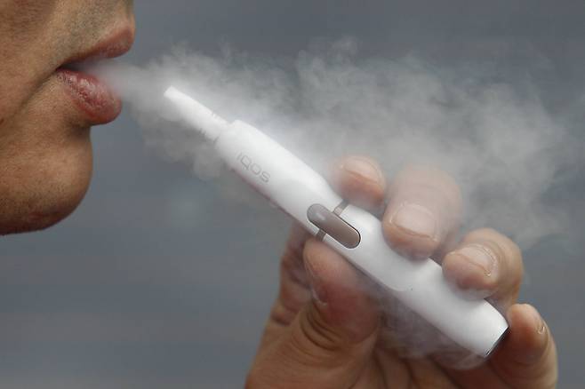 한 시민이 궐련형 전자담배를 피우는 모습. 일반 담배(궐련)와 궐련형 전자담배 못지 않게 유해한 수제담배를 강력히 규제해야 한다는 목소리가 나온다. [중앙포토]