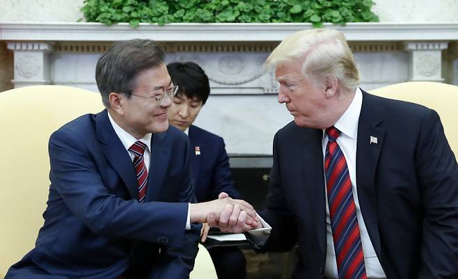 문재인 대통령과 도널드 트럼프 미국 대통령이 22일 오후(현지시간) 백악관 오벌오피스에서 열린 단독회담에서 손을 잡고 얘기를 나누고 있다. 연합뉴스