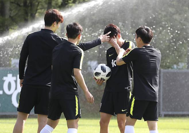 24일 파주NFC에서 열린 대표팀 훈련에서 기성용이 게임에서 벌칙을 받은 이청용에게 딱밤을 주고 있다. 박주호와 고요한이 딱밤을 주는 기성용을 도와주고 있다.임현동 기자