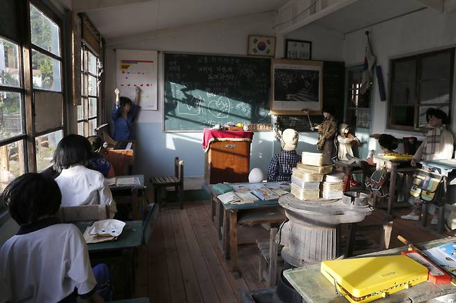 장작난로 위에 포개져 있는 양은도시락이 옛 추억을 떠올리게 하는 학교 교실 풍경. 밖에는 아이들이 문턱 닳도록 드나들며 재잘거렸을 문구사가 자리하고 있다. ⓒ이돈삼