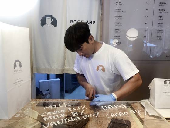 루프앤드 한남점의 공동 대표인 신화의 이민우가 나마초코라떼에 올라갈 초콜릿을 썰고 있다.