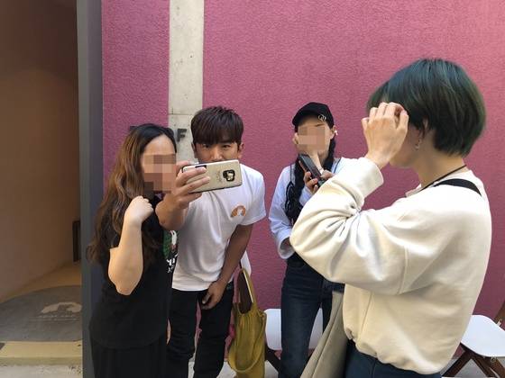 이민우 대표가 카페를 찾은 팬들과 함께 셀카를 찍어주고 있다.