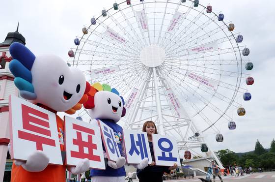 광주시선거관리위원회 직원들이 지난달 22일 오후 선거 홍보 현수막이 붙은 광주 북구 패밀리랜드 관람차 '빅아이' 앞에서 지방선거 투표 독려 캠페인을 펼치고 있다. [뉴스1]