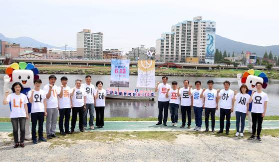 6·13지방선거 공식선거운동이 시작된 지난달 31일 전남 장흥군 탐진강에서 장흥군선거관리위원회 직원과 위원들이 투표 홍보 글자가 새겨진 티셔츠를 입고 투표 독려를 하고 있다. [장흥군 제공=연합뉴스]