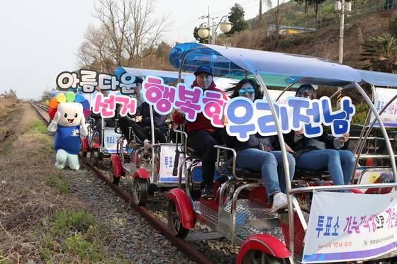 지난달 31일 전남 여수를 찾은 관광객들이 달리는 레일바이크에서 '6.13 지방선거' 투표참여 퍼포먼스를 펼치고 있다. [전남선관위 =뉴스1]