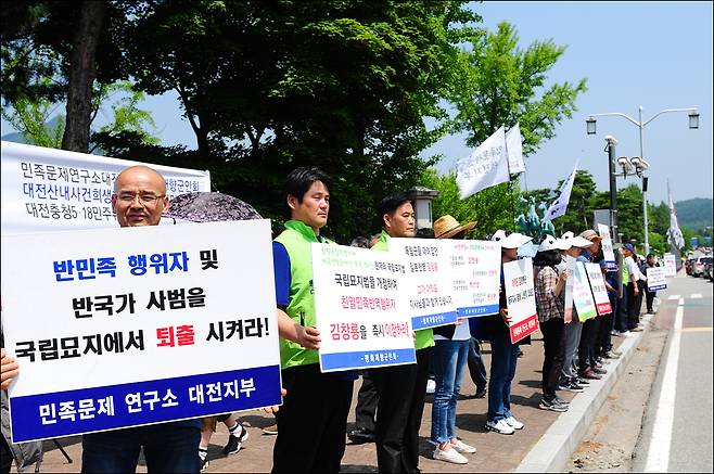 국립묘지법 개정 및 김창룡 묘 이장 촉구대회가 열린 와중, 참가자들이 피켓을 들고 서 있다.  ⓒ임재근