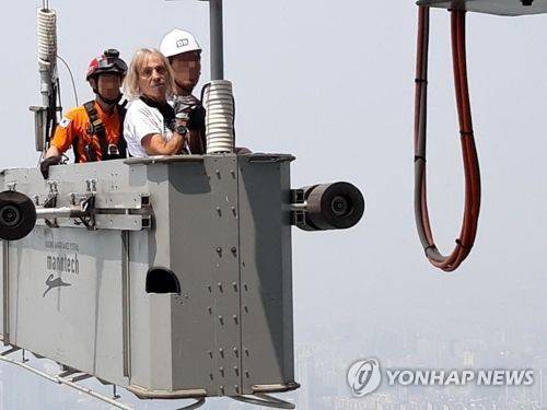 프랑스 유명 암벽등반가, 롯데월드타워 무단 등반 프랑스의 유명 암벽등반가 알랭 로베르가 6일 오전 서울 송파구 롯데월드타워 외벽을 무단으로 오르다가 경찰에 체포됐다. 사진은 롯데월드타워 등반을 중단하고 구조되고 있는 알랭 로베르. [119특수구조단 제공=연합뉴스]