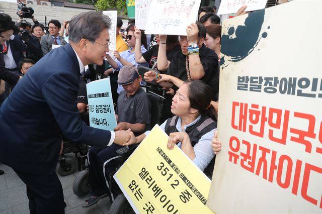 문재인 대통령이 8일 오전 서울 종로구 청와대 인근 한 투표소에서 6.13 지방선거 및 국회의원 재보궐선거 사전투표를 마치고 장애인 참정권을 요구하는 장애인단체 회원들과 대화를 나누고 있다. 현직 대통령이 사전투표에 참여하는 것은 2013년 상반기 재보선 때 사전투표제가 도입된 이후 이번이 처음이다. 청와대사진기자단