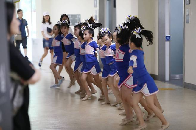 유소년 참가팀 선수들이 서로 손을 맞잡고 코치의 지도아래 단체 연습을 하고 있다. 우상조 기자