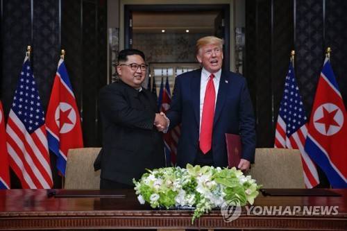 [북미정상회담] 북미, 공동합의문 서명한 뒤 악수 (싱가포르=연합뉴스) 역사적 첫 북미정상회담이 열린 12일 오후 싱가포르 센토사 섬 카펠라호텔에서 미국 도널드 트럼프 대통령과 북한 김정은 국무위원장이 공동합의문에 서명을 마친 뒤 악수하고 있다. [스트레이츠타임스 홈페이지 캡처=연합뉴스]    photo@yna.co.kr