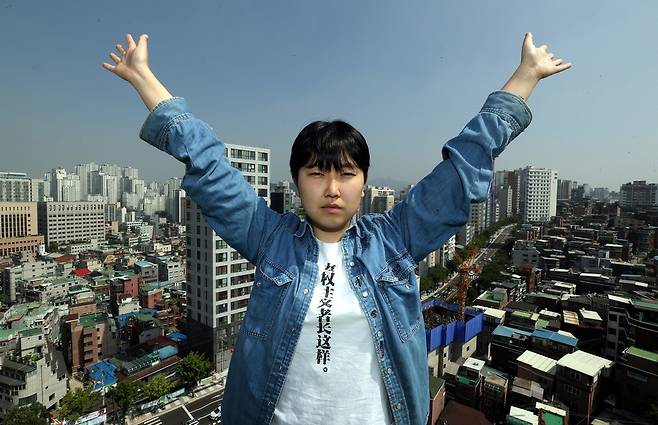 불꽃페미액션 활동가 이가현씨가 지난 5일 서울 마포구 한겨레신문사 9층 옥상에서 도심을 배경으로 하늘을 향해 두 팔을 벌리고 있다. 강재훈 선임기자 khan@hani.co.kr