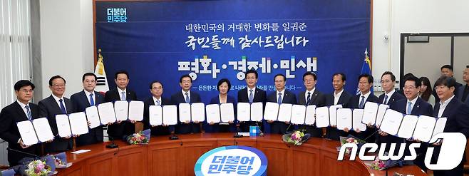 추미애 더불어민주당 대표와 홍영표 원내대표를 비롯한 시도지사 등이 지난 15일 오전 서울 여의도 국회 당대표실에서 열린 '나라다운 나라, 든든한 지방정부 실현을 위한 국민과의 약속 선포식'에서 손을 맞잡아 들어 인사하고 있다.  뉴스1 © News1 박정호 기자