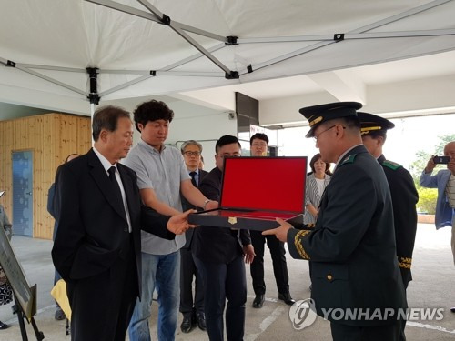 68년만에 고향으로 돌아오는 고 윤경혁 일병 (대구=연합뉴스) 이덕기 기자 = 1950년 미군 1 기병사단(카투사)에 배치돼 복무하던 중 평안남도 개천 지역에서 전사한 고 윤경혁 일병의 유해가 68년만에 고향으로 돌아온다. 사진은 50사단 관계자가 유해 송환식을 앞두고 19일 유가족에게 '호국의 얼'함을 전달하는 장면. [국방부 유해발굴감식단 제공=연합뉴스]    duck@yna.co.kr