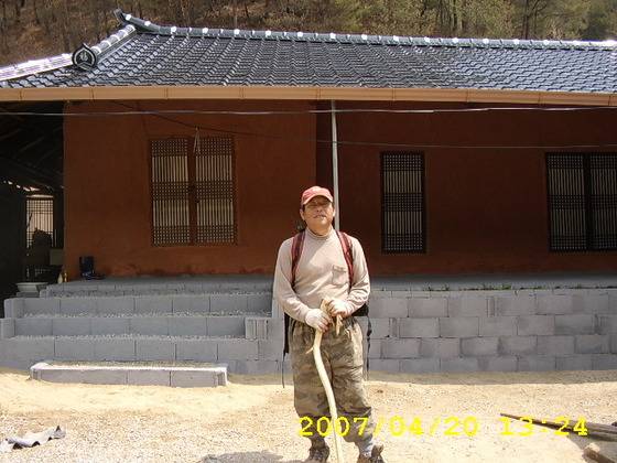 완성된 집 앞 남편의 모습. [사진 송미옥]
