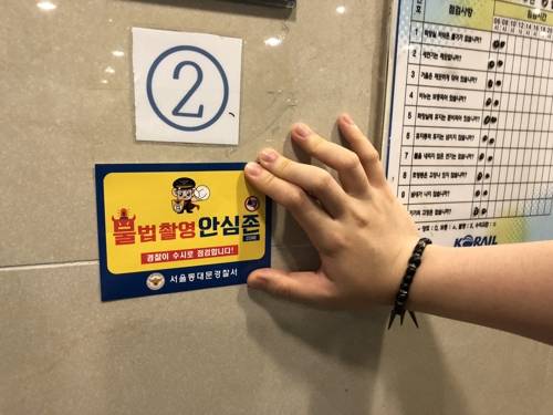 '불법촬영 안심존' 스티커 (서울=연합뉴스) 서울 동대문경찰서가 지난 20일여성가족부 인권지원팀, 동대문구청 여성안심보안관과 함께 서울 동대문구의 한 공중화장실에서 불법 촬영기기(몰카)가 있는지 합동 점검한 뒤 '불법촬영 안심존' 스티커를 붙이고 있다. 2018.6.22 [서울 동대문경찰서 제공=연합뉴스]