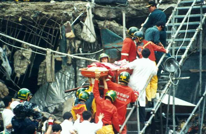삼풍백화점 붕괴 사건 현장에서 구조대원들이 생존자를 옮기고 있다. <한겨레> 자료 사진.