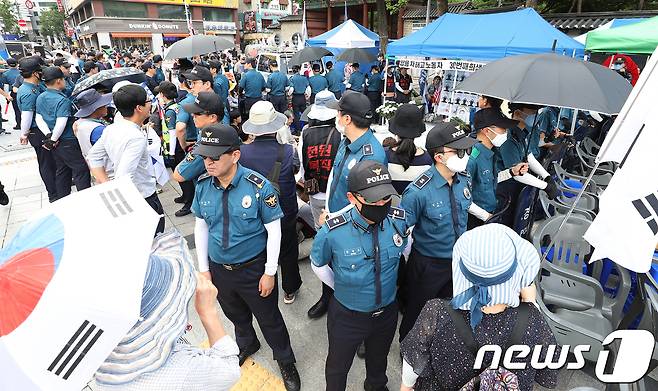 4일 오후 서울 중구 대한문 앞에 마련된 쌍용자동차 해고노동자 고 김주중씨 추모분향소 주위를 경찰이 에워싸고 경계근무를 서고 있다. 반면친박성향 보수단체 회원들이 분향소 설치에 반대하며 경찰을 사이에 두고 노동조합·시민단체 관계자들과 대치하고 있다. 2018.7.4/뉴스1 © News1 신웅수 기자