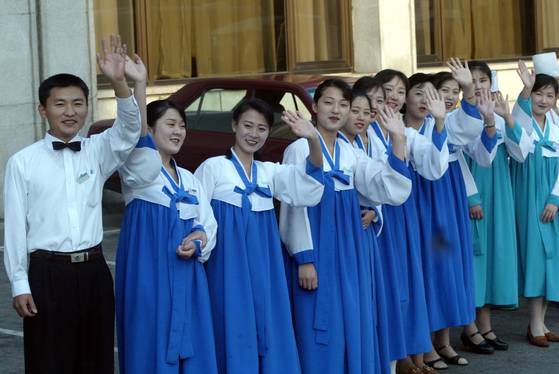 지난 2003년 10월 파란저고리의 한복을 입은 고려호텔 직원들이 정주영 체육관 개관을 기념해 열린 남북통일농구대회와 개관식에 참가한 방북단을 배웅하고 있다. [중앙포토]