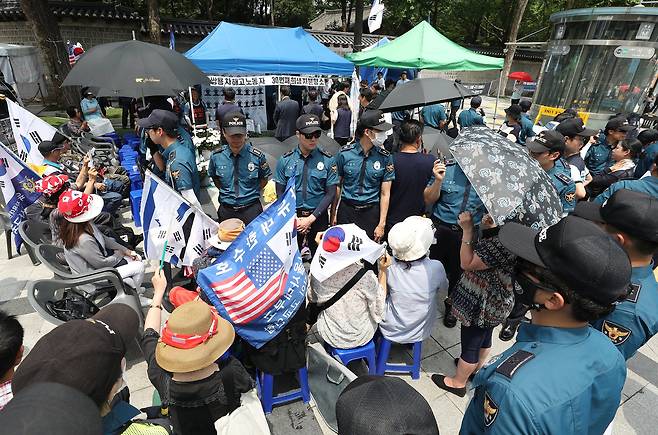 4일 오후 서울 중구 대한문 앞에 마련된 쌍용자동차 해고노동자 고 김주중씨 추모분향소 주위를 경찰이 에워싸고 경계근무를 서고 있다. 금속노조는 지난 3일 쌍용차 해고노동자를 추모하는 분향소를 설치하려했지만 친박성향 보수단체 회원들이 분향소 설치에 반대하며 경찰을 사이에 두고 와 노동조합·시민단체 관계자들과 대치하고 있다. [뉴스1]
