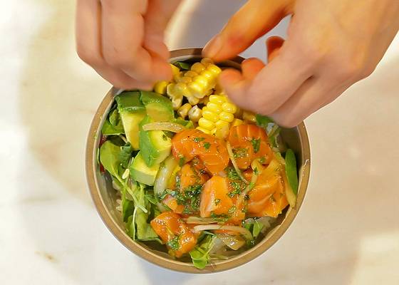 밥 위에 채소를 올리고 소스에 버무린 연어, 아보카도, 옥수수를 올려 완성한다.