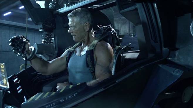 영화 아바타의 등자인물 쿼리치 대력이 AMP슈트를 조작해 보고 있다. AMP슈트는 사람이 조종석에 앉아 로봇을 조종하는 탑승형 로봇이다.