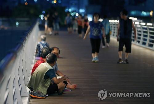 지난 17일 밤 강원 강릉시 시민들이 남대천을 가로 지르는 월화교에 나와 시원한 강바람에 몸을 식히고 있다. 월화교는 열차가 지나다니던 철교를 보행 공간으로 탈바꿈한 곳이다. [연합뉴스 자료사진]