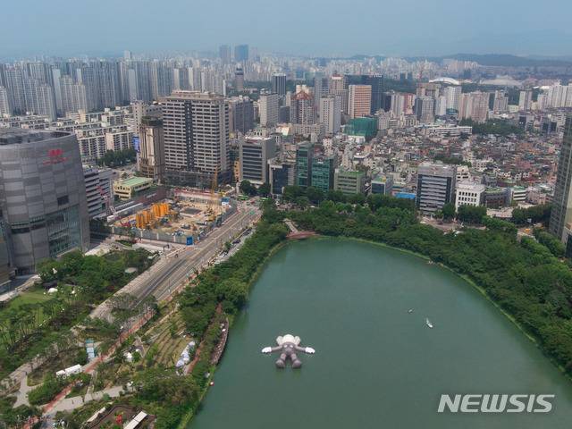 【서울=뉴시스】 박현주 미술전문기자 = 롯데가 공공미술 프로젝트로 석촌호수에 띄운 '카우스:홀리데이' 컴패니언이 하늘을 보고 누워있다. 길이 세로 28m, 가로 25m, 높이 5m 초대형 조형물이다.