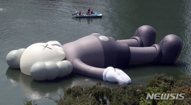 【서울=뉴시스】김선웅 기자 = 19일 오후 서울 송파구 석촌호수에서 롯데와 송파구가 함께한 팝 아티스트 '카우스(KAWS)'의 공공 미술 프로젝트 '카우스:홀리데이 코리아(KAWS:HOLIDAY KOREA)'가 전시되고 있다. ‘카우스:홀리데이(KAWS:HOLIDAY)’는 길이 28M(세로), 25M(가로), 5M(높이)의 독창적인 캐릭터를 활용해 ‘일상으로부터 탈출해 모든 것을 잊고 세상을 바라보며 휴식을 취하는 모습’을 표현한다. 전시는 다음달 19일까지 관람할 수 있다. 2018.07.19. photo@newsis.com