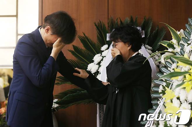 조국 청와대 민정수석이 24일 서울 서대문구 연세대 세브란스병원 장례식장에 마련된 고(故) 노회찬 정의당 원내대표 빈소에서 노 원내대표의 부인 김지선 씨의 손을 잡고 눈물을 흘리고 있다.  © News1 사진공동취재단