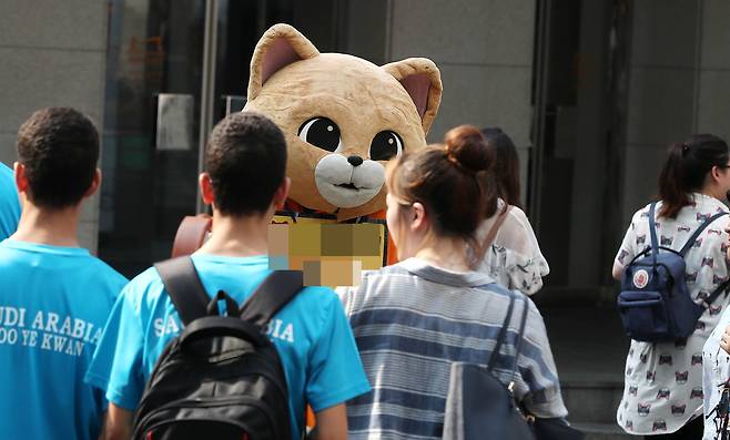 절기상 대서 폭염이 이어진 23일 오후 서울 중구 명동에서 고양이 탈을 쓴 알바생이 홍보하고 있다.[뉴시스]