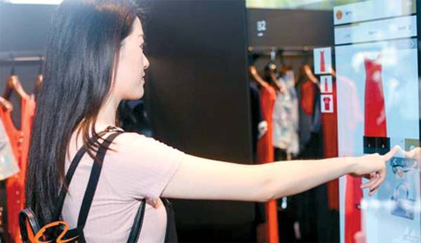 알리바바그룹이 지난 4일 홍콩 이공대학에서 선보인 인공지능 의상 코디 플랫폼 `패션 AI`를 한 여성이 시연해 보고 있는 모습. [사진 제공 = 알리바바그룹]