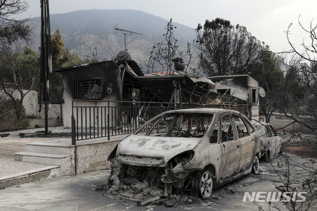 【마티(그리스)=AP/뉴시스】대형 산불이 발생한 그리스 아테네의 키네타 마을의 한 불타버린 집 앞에 24일 타다 남은 자동차 한 대가 놓여 있다. 강풍으로 산불이 계속 확산되고 있는 가운데 최소 50명이 사망한 것으로 우려되고 있다. 2018.7.24