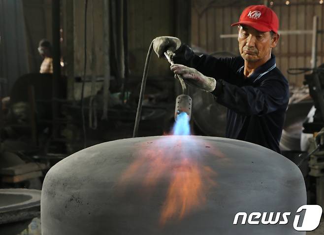 29일 경북 구미시 고아읍 사랑채 가마솥공장에서 권태원(66)씨가 마사토로 만든 중자(내부 거푸집)에 흑연을 묻힌뒤 토치로 열을 가하고 있다.2018.7.29/뉴스1 © News1 정우용 기자