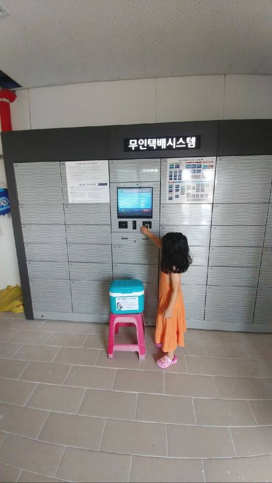 25일 루리웹에 올라온 사진. 박재찬(38)씨 딸 다인(6)양이 무인택배함 앞에 아이스박스를 놓고 있다. [사진 박재찬씨 제공]