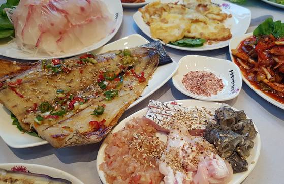 목포 시내 민어의 거리에 있는 민어 전문점 '중앙식당'의 민어 정식 상차림. 맨 앞에 별미로 꼽히는 민어 부레와 데친 껍질과 내장이 있다. 바로 뒤의 음식이 민어찜이다. 손민호 기자