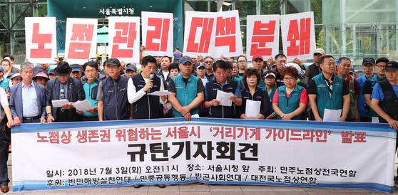 민주노점상전국연합 소속 상인들이 지난달 3일 서울시청 앞에서 '서울시 거리가게 가이드라인'을 반대하는 기자회견을 열고 있다.［연합뉴스］