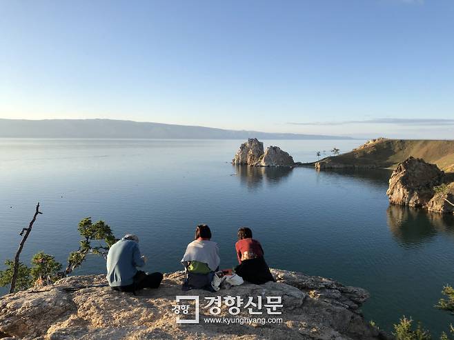 멀리 알혼섬의 랜드마크인 부르한 바위(샤먼 바위)를 바라보며 석양을 기다리는 여행객들. ‘부르한’은 바이칼 일대에서 신성한 장소를 일컫는 말이다.