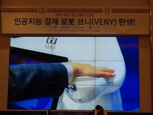 마용득 롯데정보통신 대표가 핸드페이 기술로 생수(500원)를 결제하고 있다.