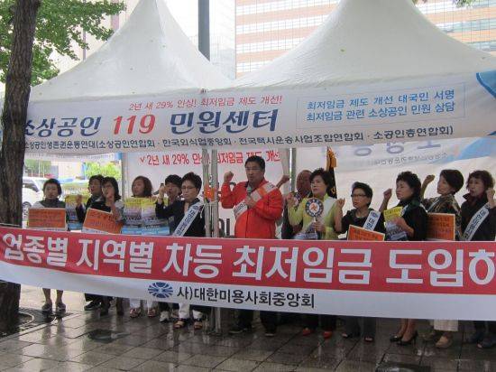 27일 서울 광화문 현대해상 건물 앞에 설치된 '소상공인 119민원센터'에서 최영희 대한미용사회중앙회 회장(왼쪽 여섯번째)과 최승재 소상공인연합회 회장(왼쪽 일곱번째)이 '업종별·지역별 최저임금 차등적용'을 촉구하고 있다.