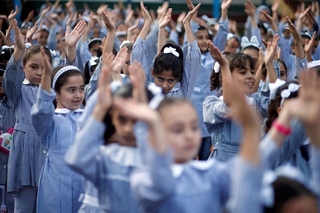 가자시티의 국제연합 팔레스타인 난민 구호기구(UNRWA)가 운영하는 학교에서 새학기 첫날을 맞은 29일(현지시간)  팔레스타인 학생들이 아침 운동을 하고 있다.  로이터 연합뉴스