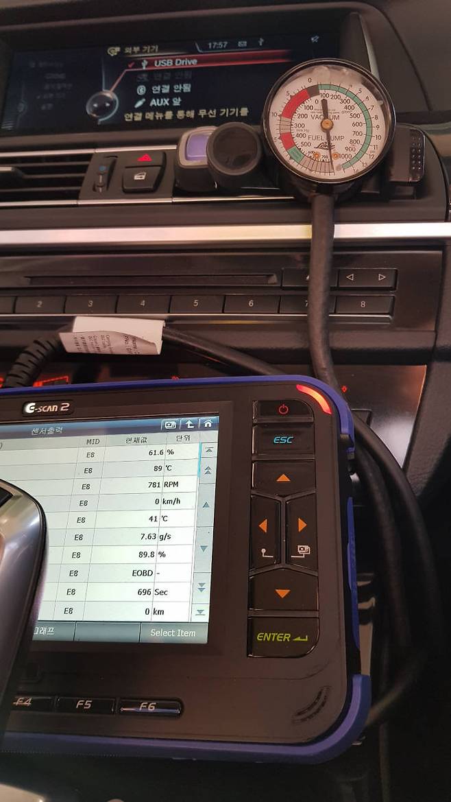 주행 중인 BMW 520d 차량, ECU 진단기에 냉각수 온도는 89도, 진공측정기 수침을 통해 바이패스 밸브가 열린 상태임을 확인할 수 있다. (전자신문 DB)