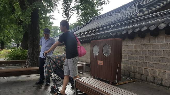 무더위가 기승을 부린 지난 7월26일, 전주시가 관광객들이 더위를 식히도록 한옥마을 경기전 돌담 주변에 설치한 쿨링포그시스템 기계(물입자를 뿌려줌) 앞에서 사람들이 더위를 식히고 있다. 이 시스템은 30초를 가동한 뒤 5초 동안 멈춘다. 박임근 기자