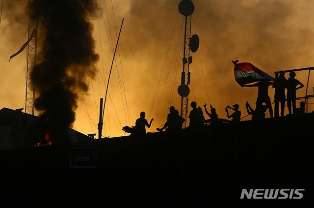 【바스라(이라크)=AP/뉴시스】이라크 남부 바스라에서 7일 열악한 공공 서비스 및 일자리 부족에 항의하는 성난 시위대가 바스라 주재 이란 영사관을 공격해 방화하면서 이란 영사관 건물에서 불길과 검은 연기가 치솟고 있다. 2018.9.8